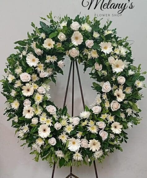 Corona de condolencias con rosas y flores blancas