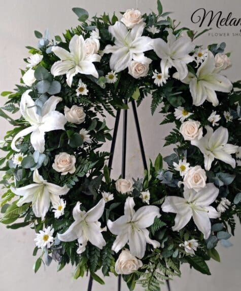 Corone de pesame con rosas lirios y eucalipto