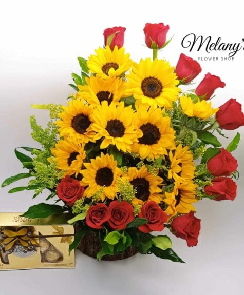 Arreglo con rosas al rededor y girasoles, acompañados de una caja de chocolates Ferrero Rocher